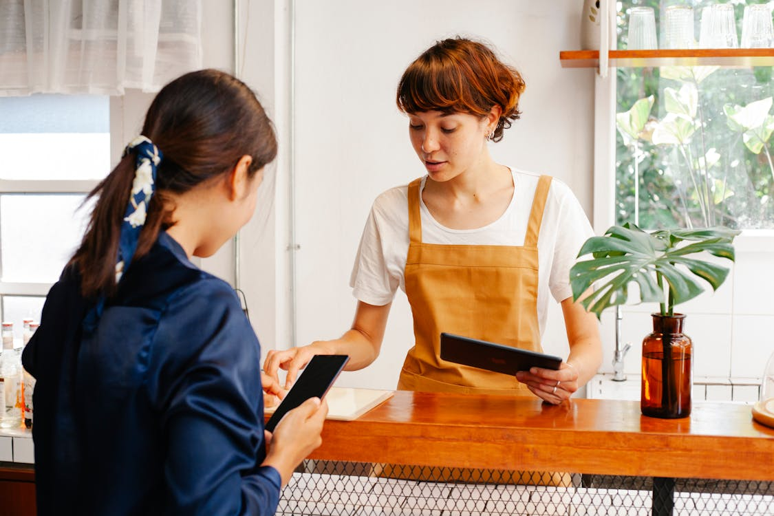 Customer at a cafe counter considering a stamp card offer