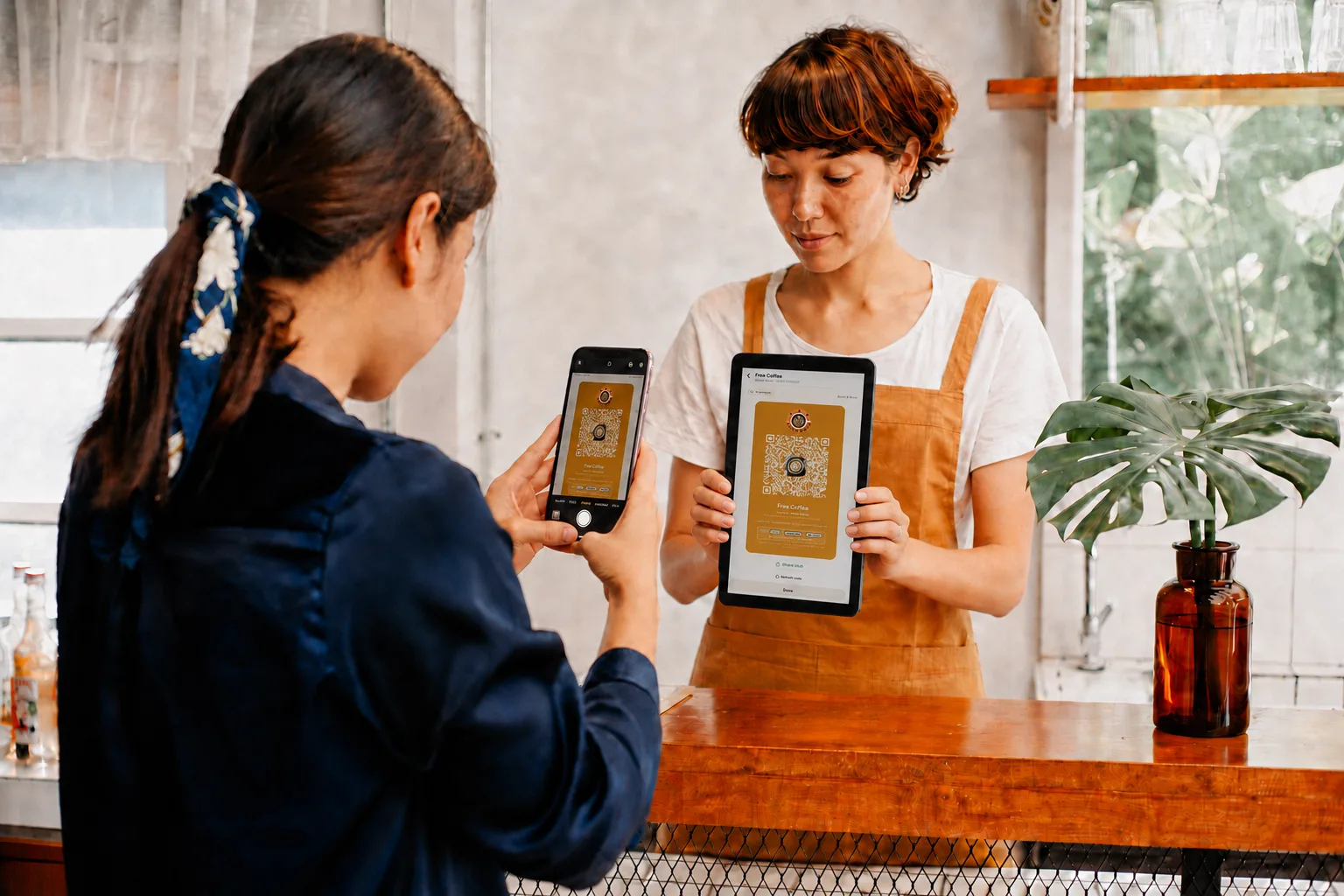 A customer photographing a claim stub QR code from a tablet screen